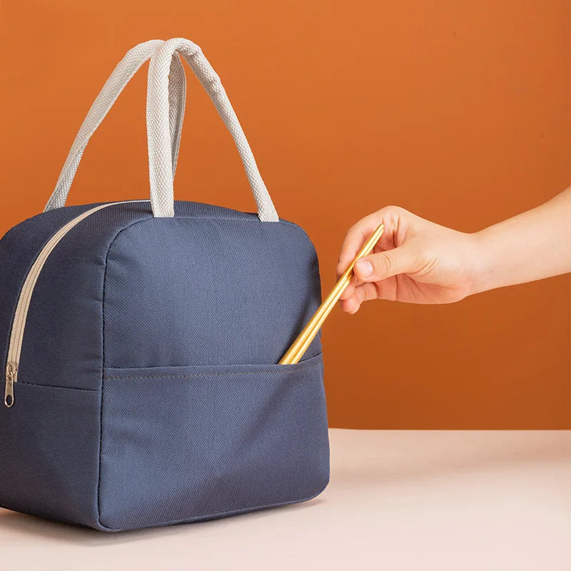 Blue kawaii bag with white handles on a beige surface against an orange background