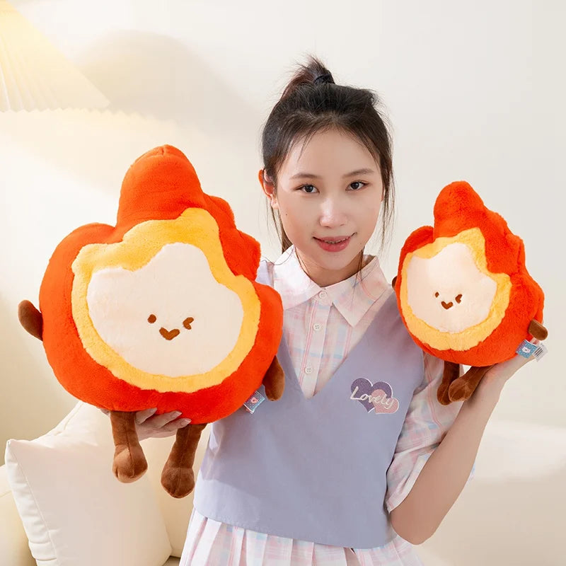 Person holding two fire-themed kawaii plush toys against a light background