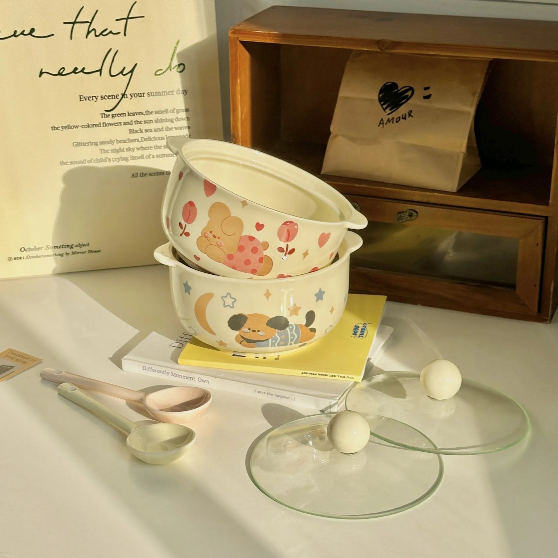Set of cartoon-themed kawaii ramen bowls with lids on a surface with books and a bag in the background.