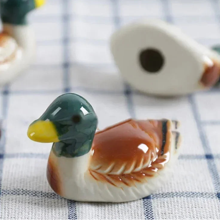 Ceramic duck kawaii chopsticks holders on a checkered cloth background
