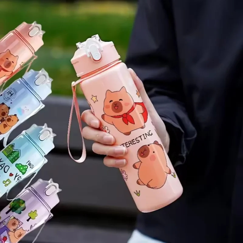 Person holding a pink kawaii water bottle with cartoon pig design, surrounded by more water bottles.