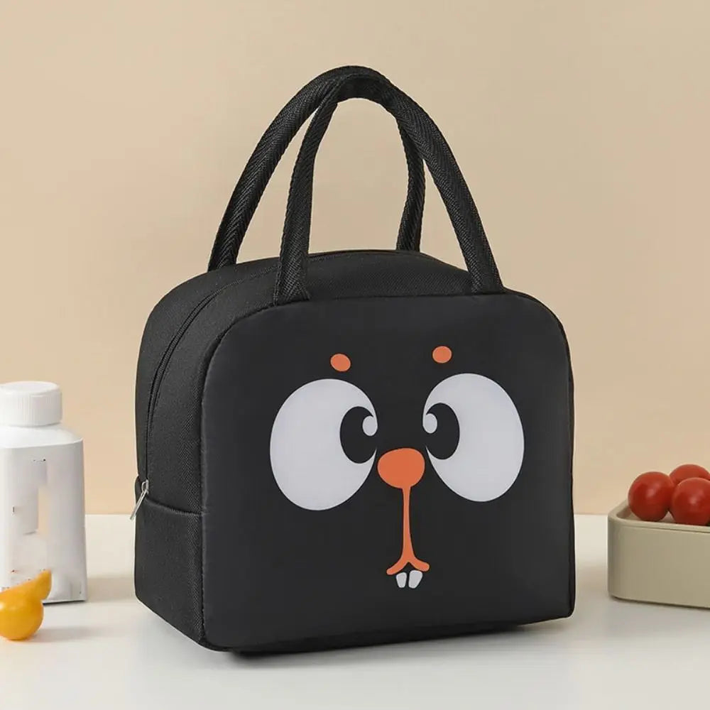 Black kawaii lunch bag with cartoon face design on a beige background