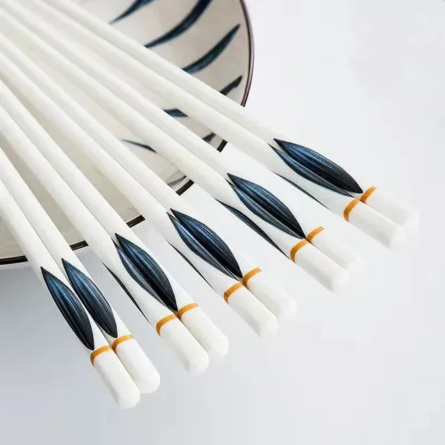 Set of white kawaii chopsticks with black bristles on a light gray background