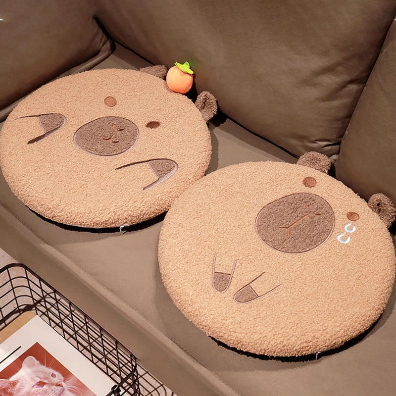 Two round, plush bear kawaii cushions on a sofa with a small basket and magazine in the background.