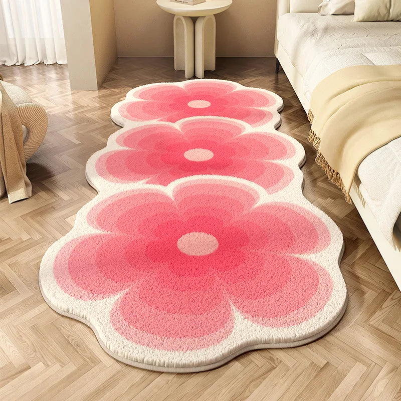 Floral-shaped pink kawaii rug on a wooden floor with a bed and chair in the background.
