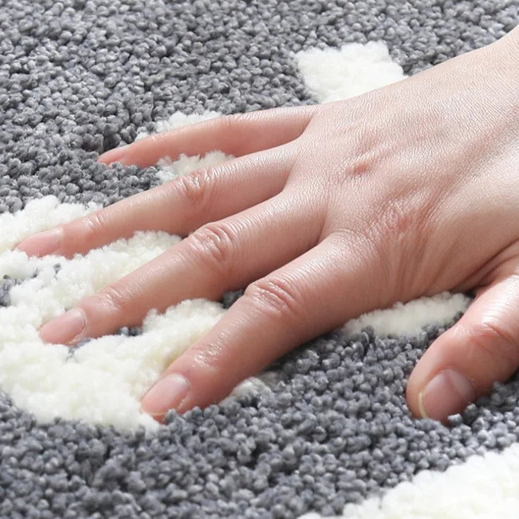 Hand pressing down on a textured gray and white kawaii rug