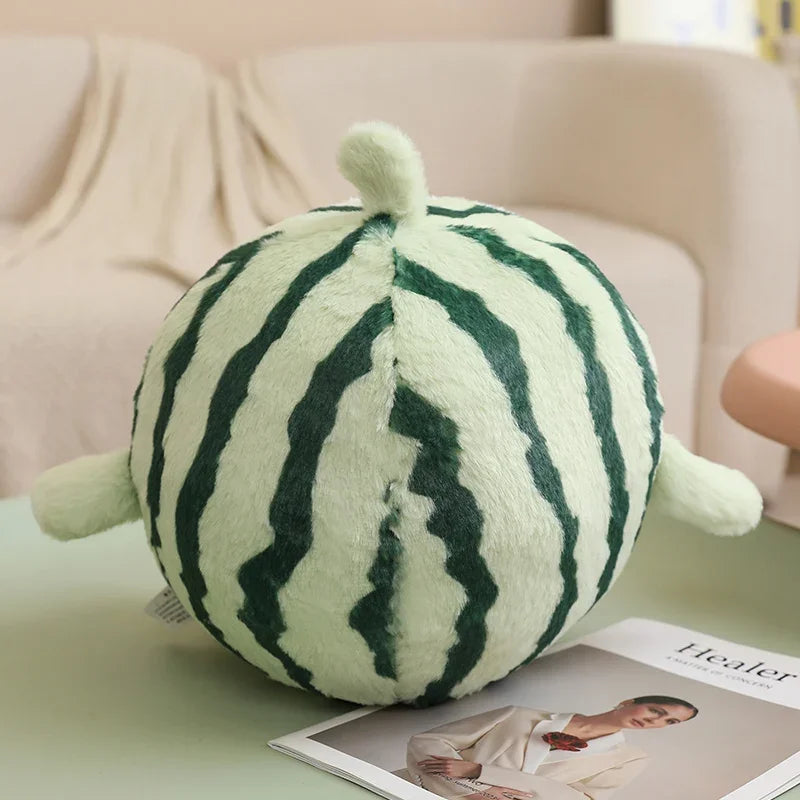 Kawaii plush toy shaped like a watermelon on a table with a magazine in the background.