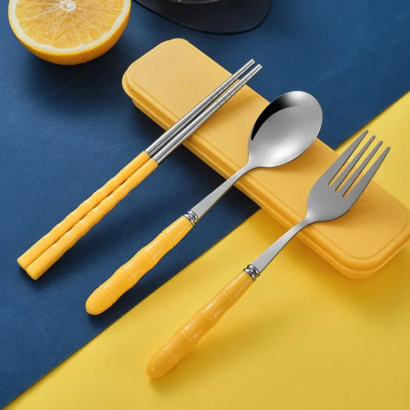 Yellow-handled kawaii utensils set with a spoon, fork, and chopsticks on a blue and yellow background.