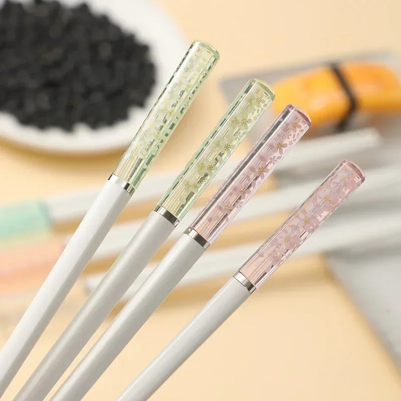 Three kawaii chopsticks with decorative caps on a blurred background
