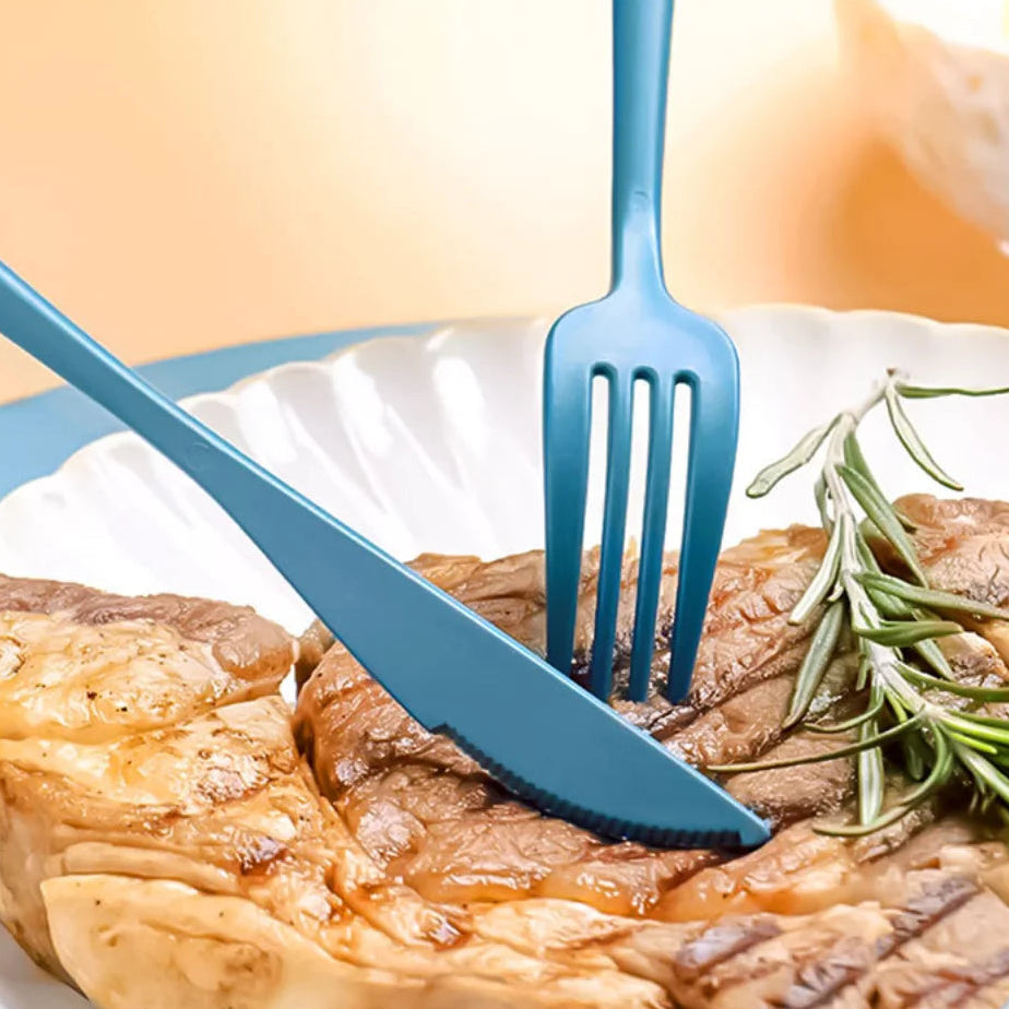 Blue kawaii utensils on a plate with cooked meat and rosemary