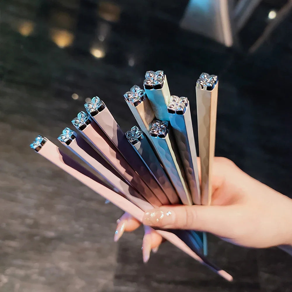 Hand holding a set of kawaii chopsticks with gemstone-like ends on a blurred background