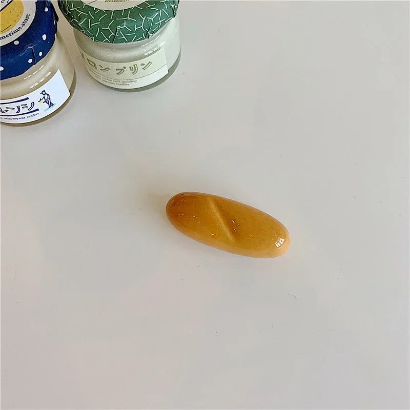 Yellow bread shaped kawaii chopstick holder on a white surface with jars in the background