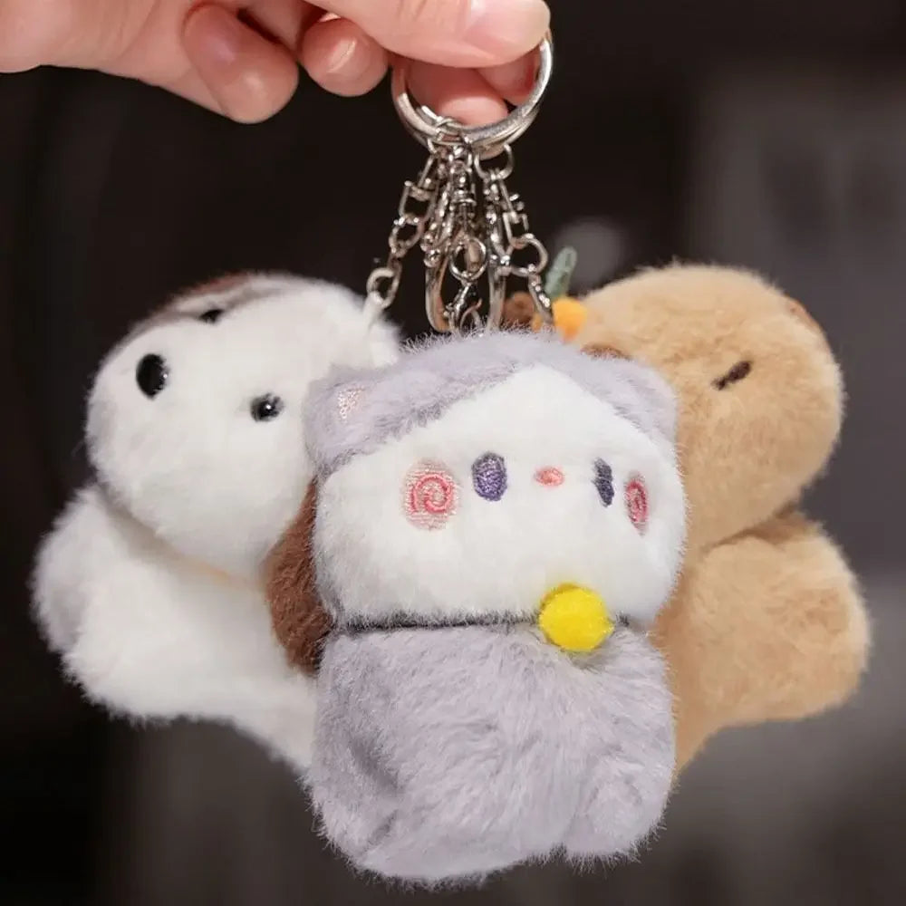 Plush keychain with three kawaii characters on a dark background