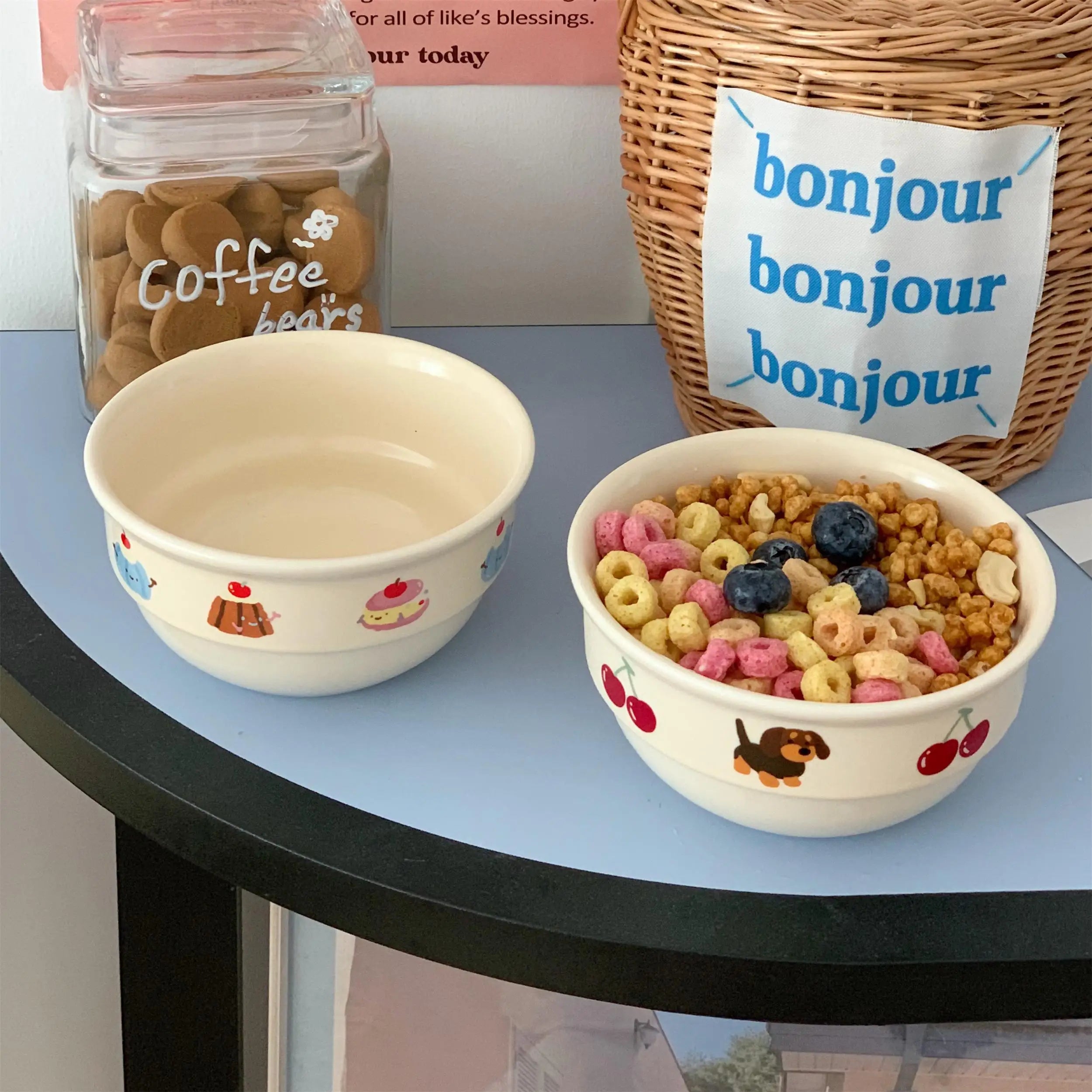 Two ceramic kawaii ramen bowls with animal illustrations on a table, one containing cereal.