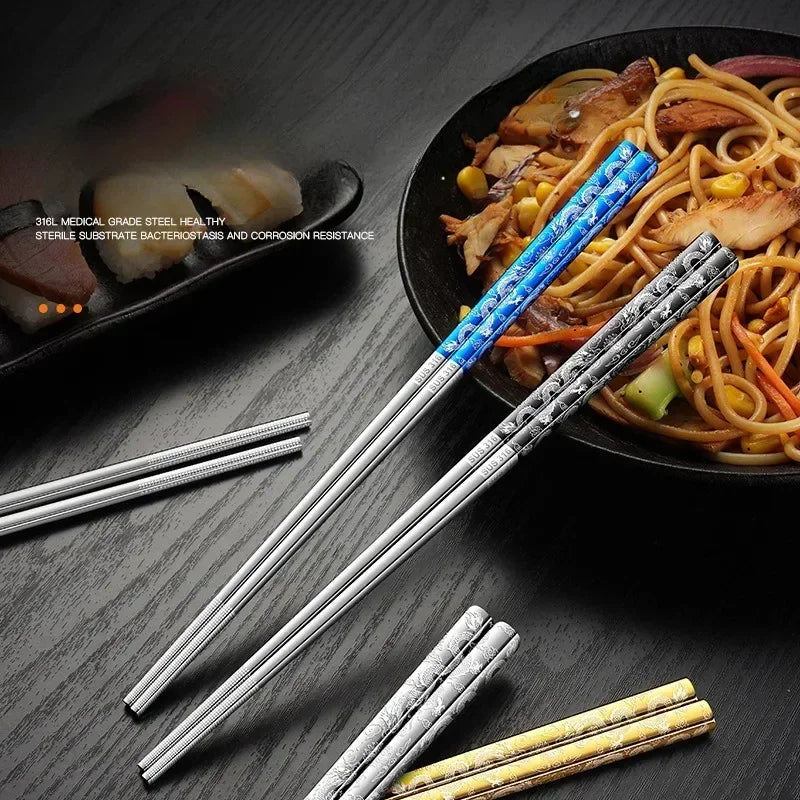Set of metal kawaii chopsticks with blue handle on a wooden surface next to a bowl of noodles.