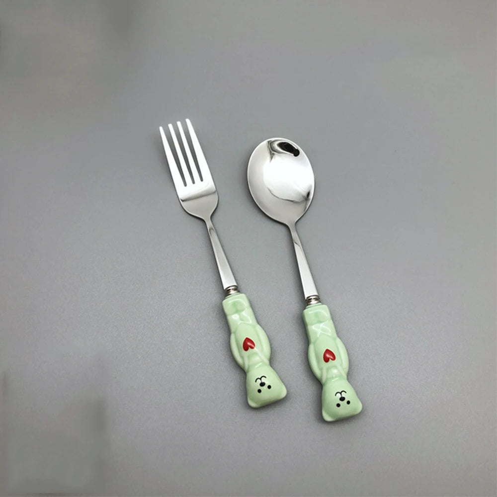 Green, bear shaped kawaii utensils on a gray background