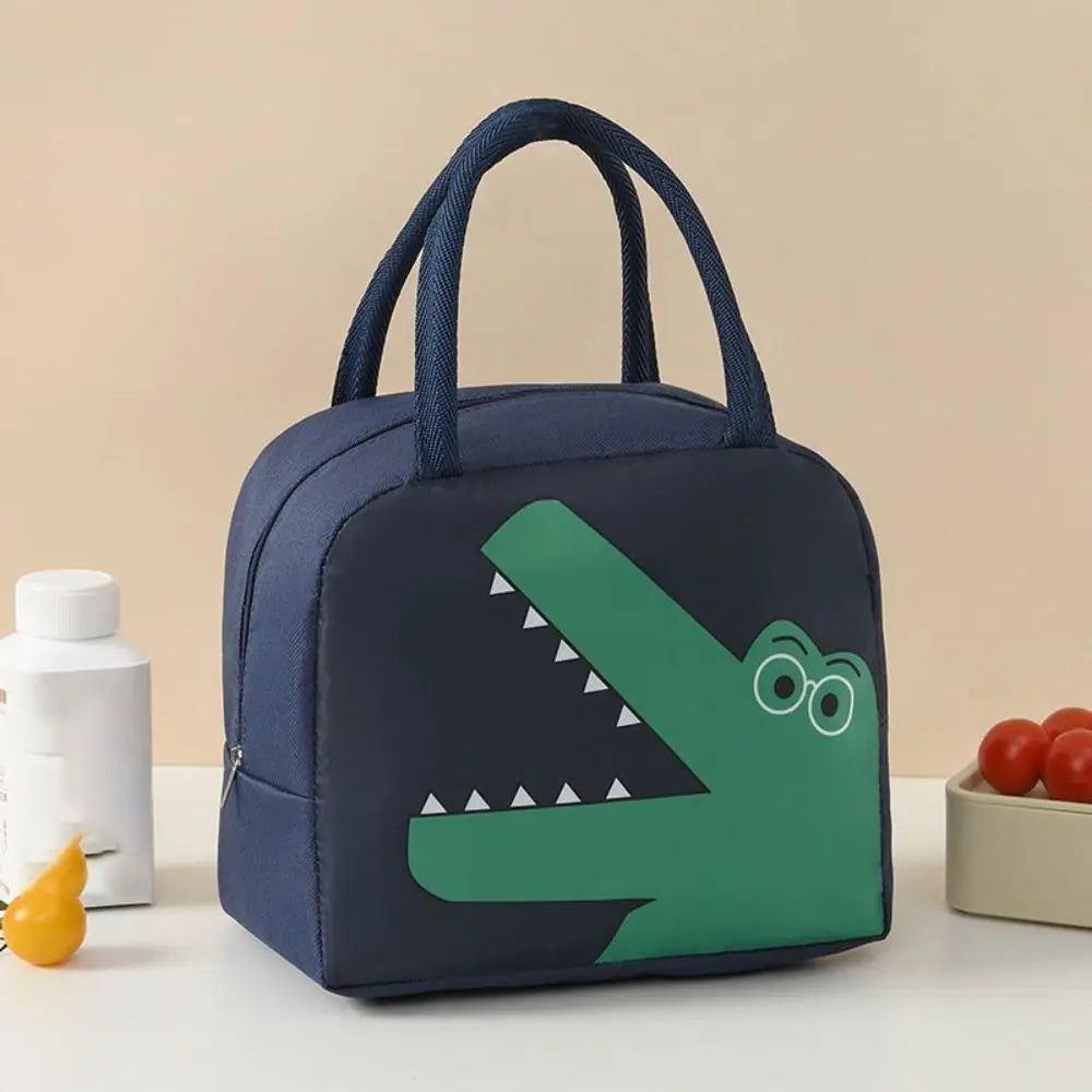 Navy blue kawaii lunch bag with green alligator design on a beige background