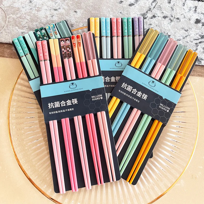 Set of colorful kawaii chopsticks in packaging on a glass plate with a marble background