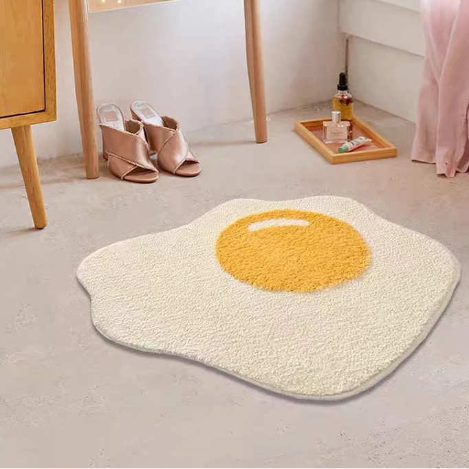Fried egg-shaped kawaii rug on a light gray floor with a wooden cabinet and mirror in the background.