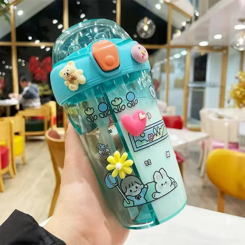Children's cartoon-themed kawaii water bottle held in a hand with a blurred indoor background