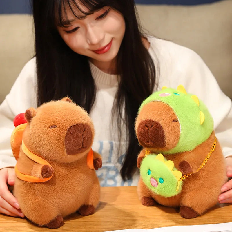 Person holding two kawaii plush toys resembling animals in colorful outfits on a wooden surface.