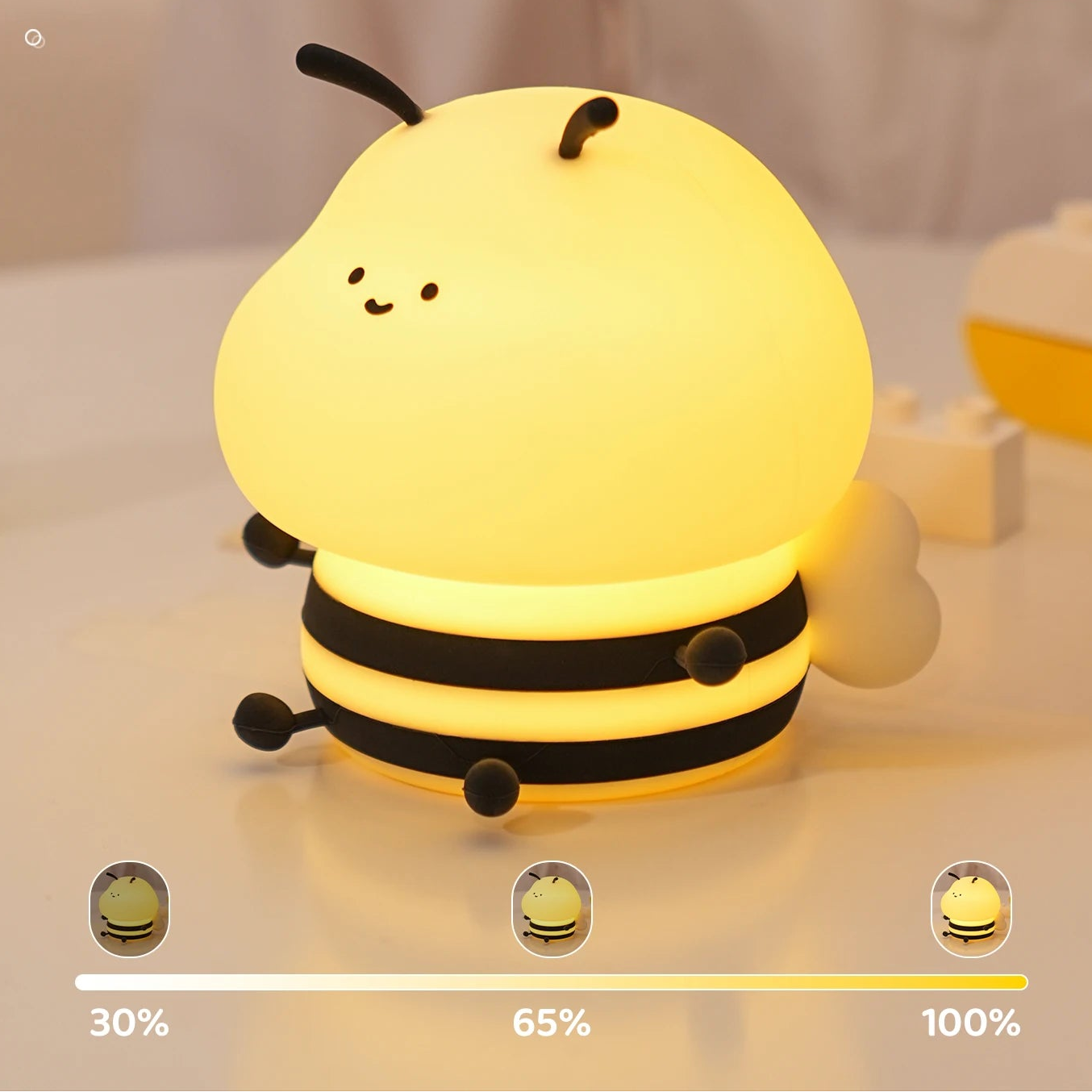 Bee-shaped kawaii night light with adjustable brightness on a soft surface