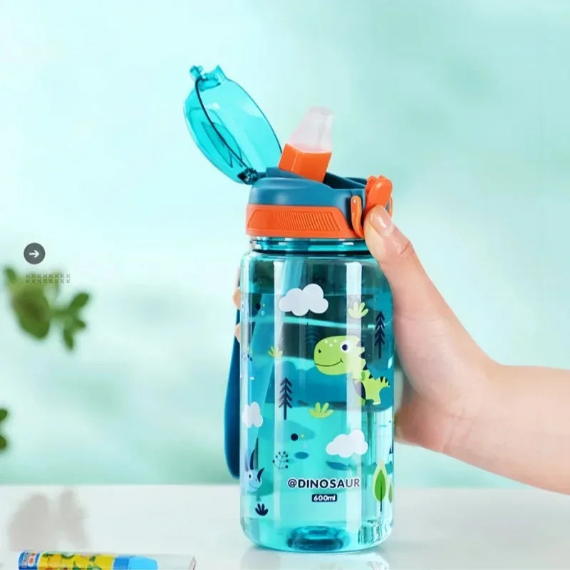 Children's kawaii water bottle with dinosaur design held by a hand against a light blue background