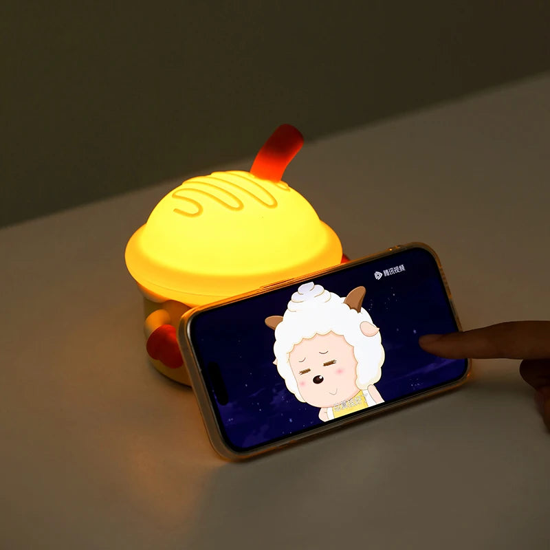 Smartphone displaying a cartoon sheep on a yellow kawaii toy with red accents.