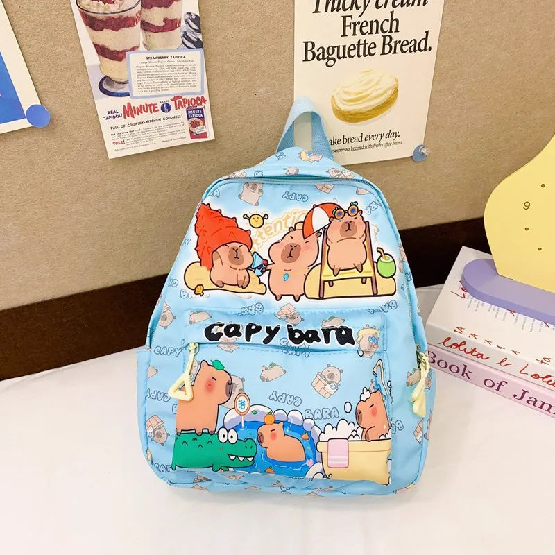 Blue backpack with Kawaii cartoon designs on a surface with posters in the background