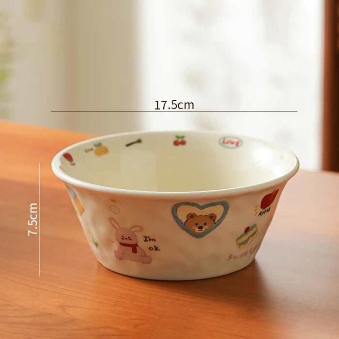 Ceramic kawaii ramen bowl with cartoon designs on a wooden surface, showing measurements.