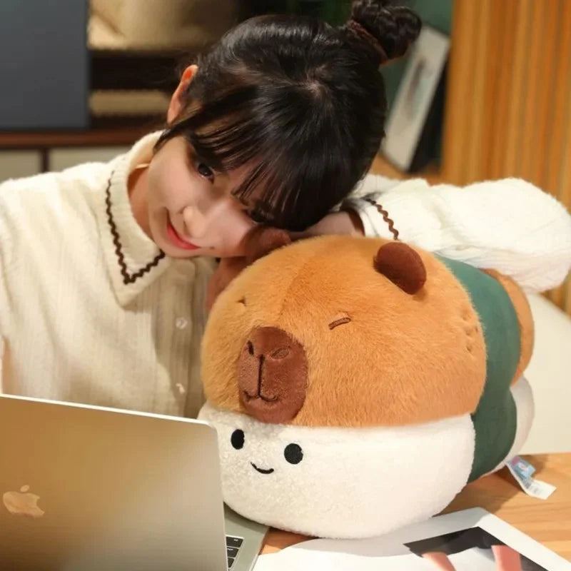 Person with a kawaii plush toy resembling a cartoon character in front of a laptop.