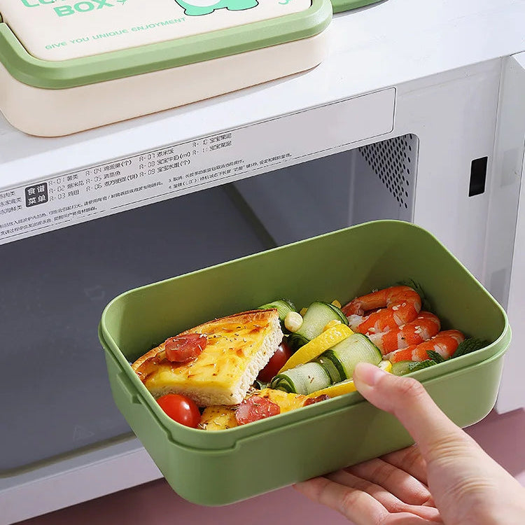 Green kawaii bento box with food held in front of a microwave