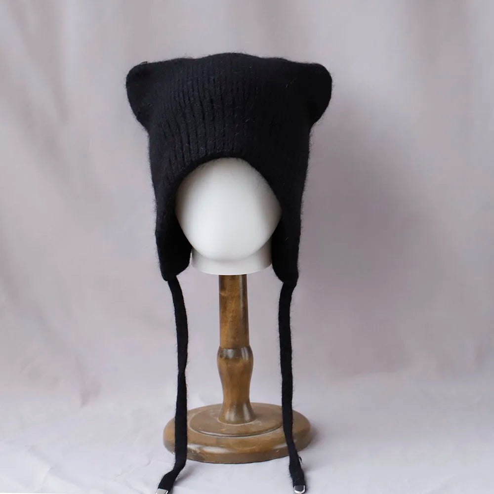 Black knitted Kawaii hat on a mannequin head against a plain background