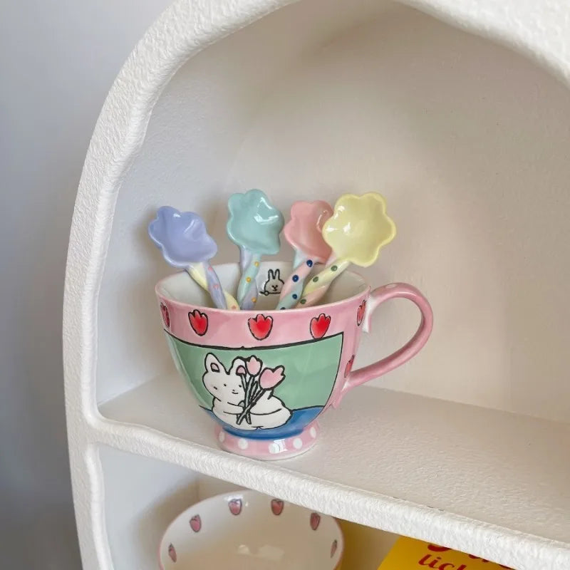 Colorful ceramic kawaii spoons with cartoon design and matching spoons on a shelf.