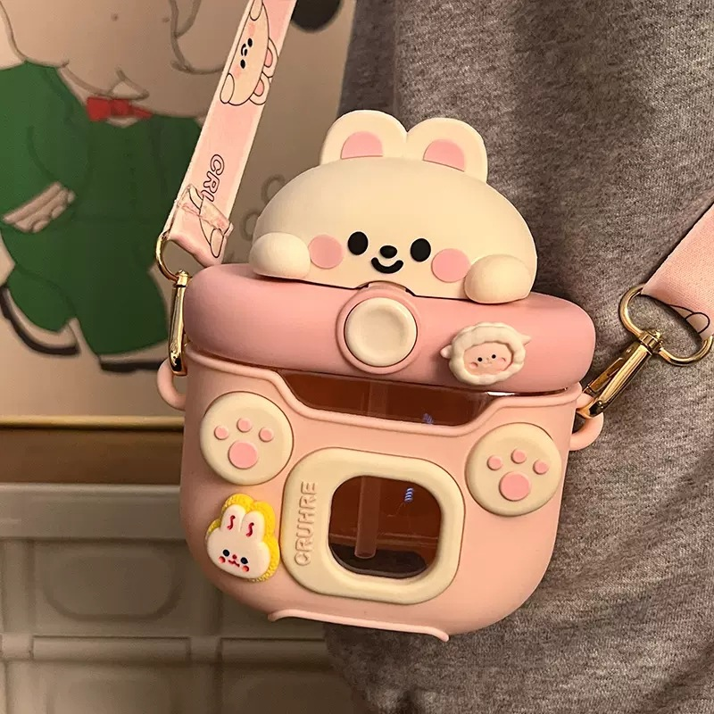 Pink cartoon-style kawaii water bottle with a bear design on a person's shoulder.