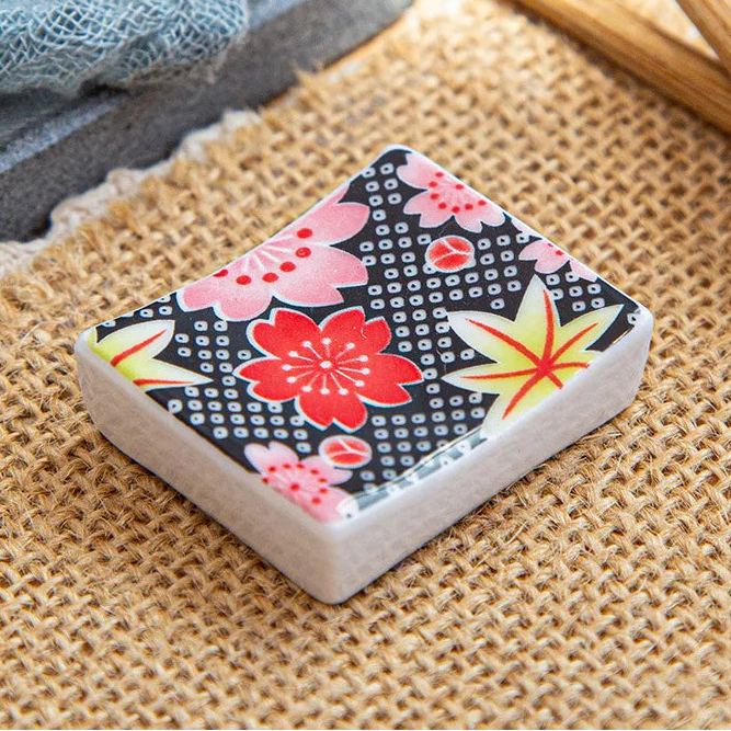 A square shaped kawaii chopstick holder with a patterned flower design