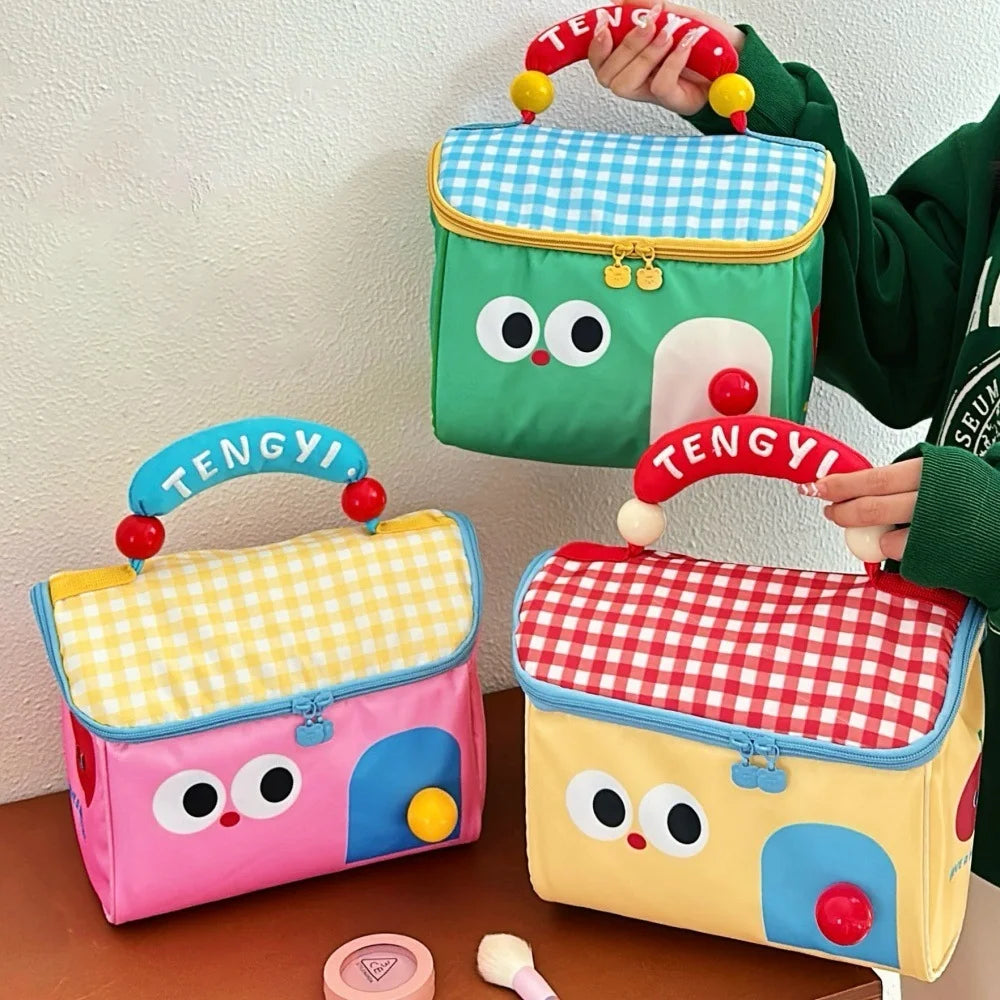 Colorful children's kawaii lunch bags with cartoon faces and 'TENGYI' branding on a wooden surface.