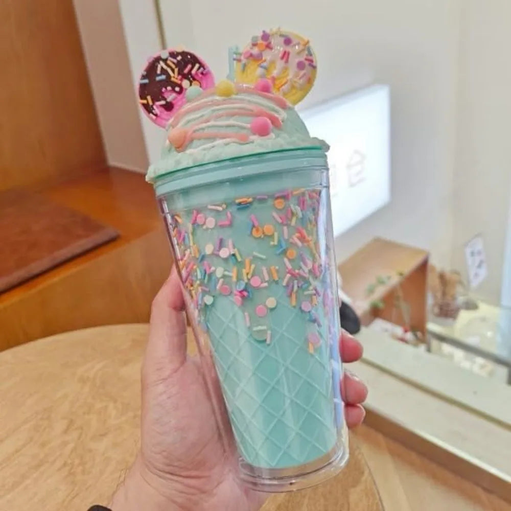 Turquoise kawaii tumbler with colorful sprinkles and donut-shaped lid held by a hand indoors.