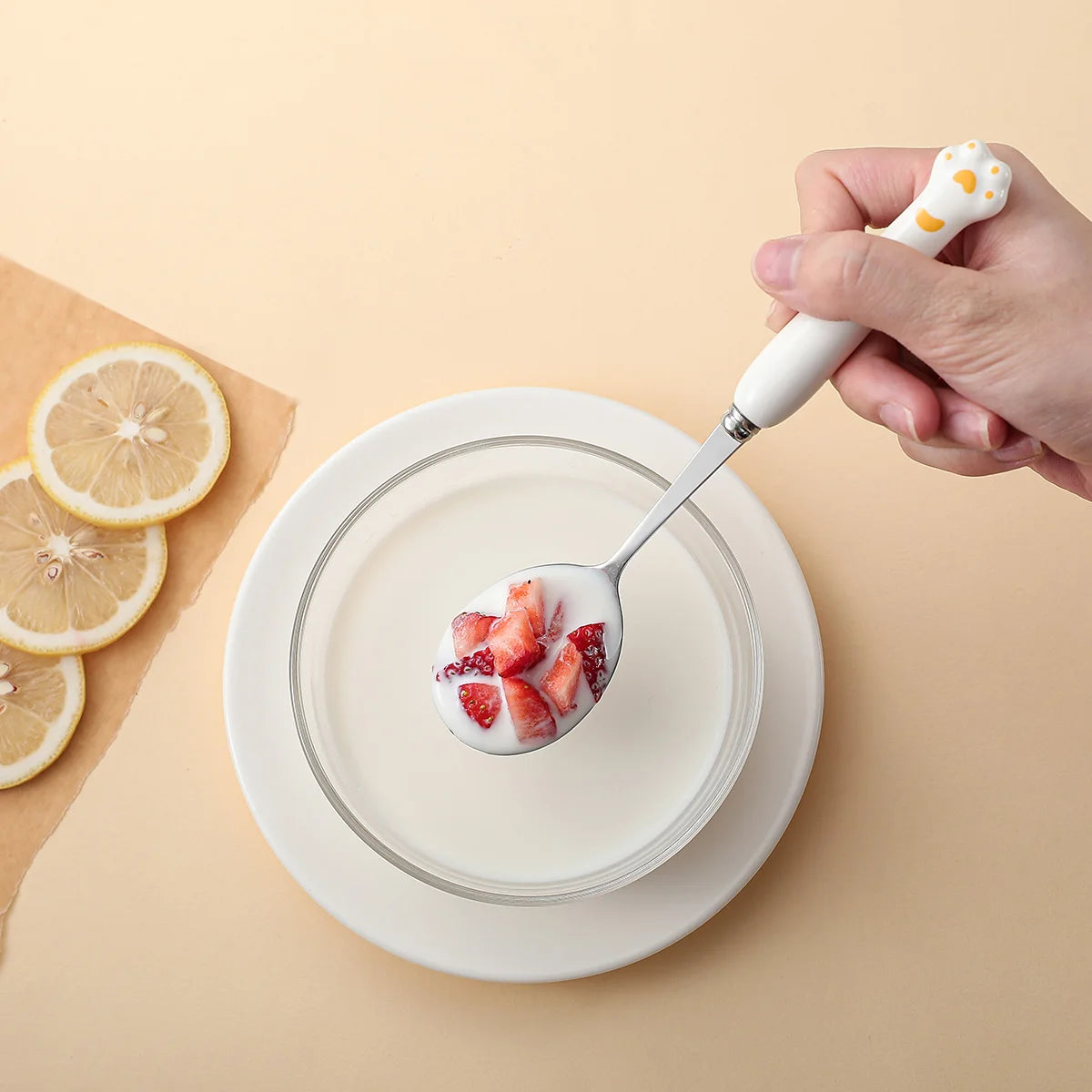 Someone eating from a white, paw shaped kawaii utensil
