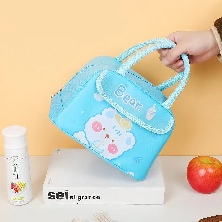 Blue kawaii lunch bag with bear design held by a hand on a yellow background, with 'sei si grande' branding.