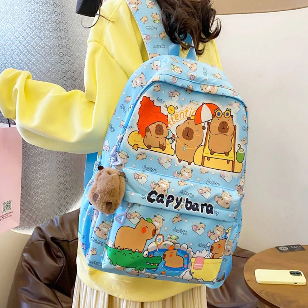 Person wearing a Kawaii blue backpack with cartoon characters, sitting on a chair.