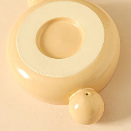 Yellow ceramic kawaii ramen bowl with a textured surface on a beige background