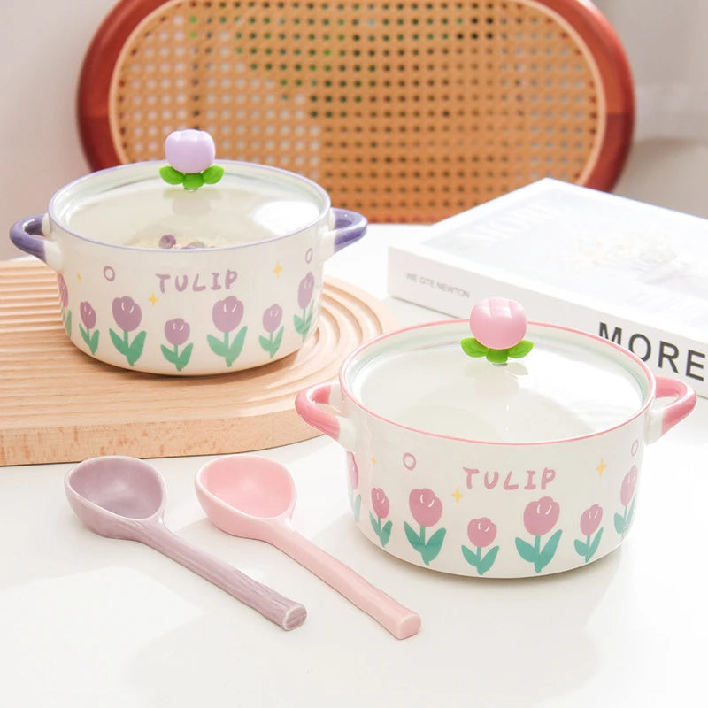 Two ceramic kawaii ramen bowls with floral designs and matching spoons on a table.
