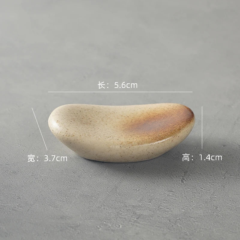 Small ceramic kawaii chopstick holders with dimensions on a gray background