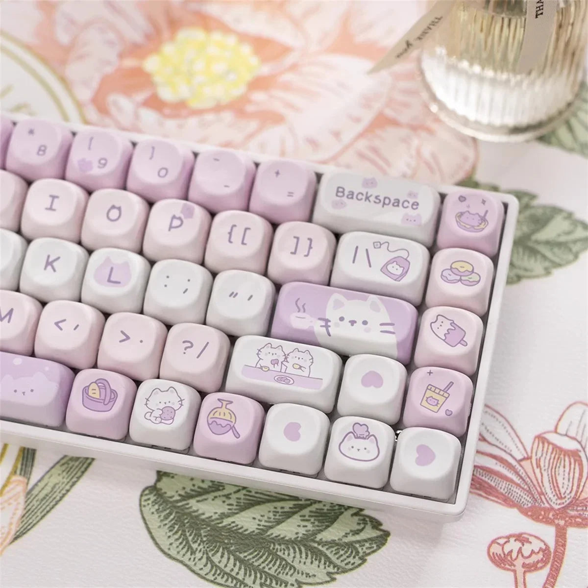 Keyboard keycaps with Kawaii illustrations on a floral background