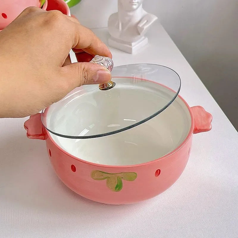 Someone opening up a lid on a kawaii bowl designed like a strawberry