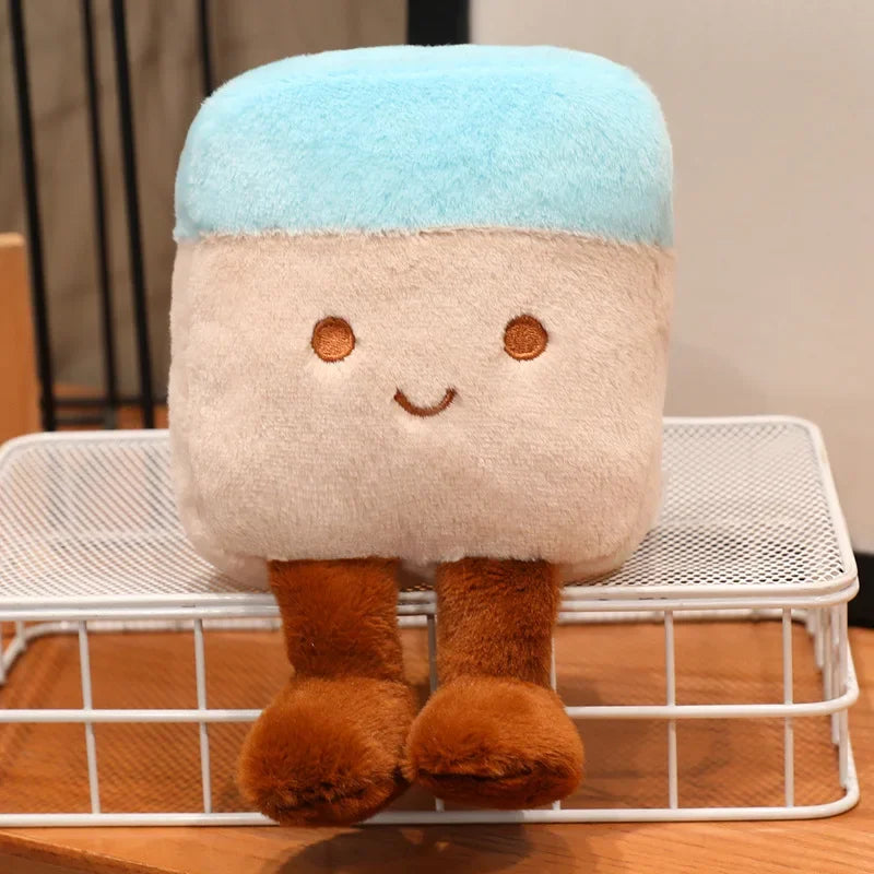 Cute kawaii plush toy with a blue top and brown bottom on a white metal stand.