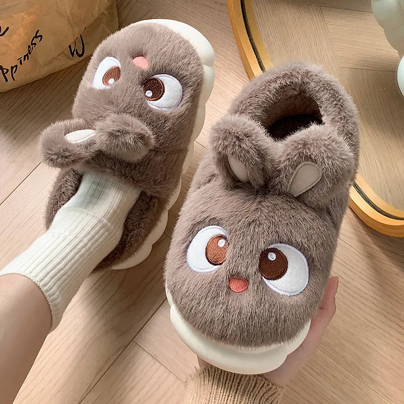 Brown cartoon-style kawaii slippers with white sole worn indoors on a wooden floor.