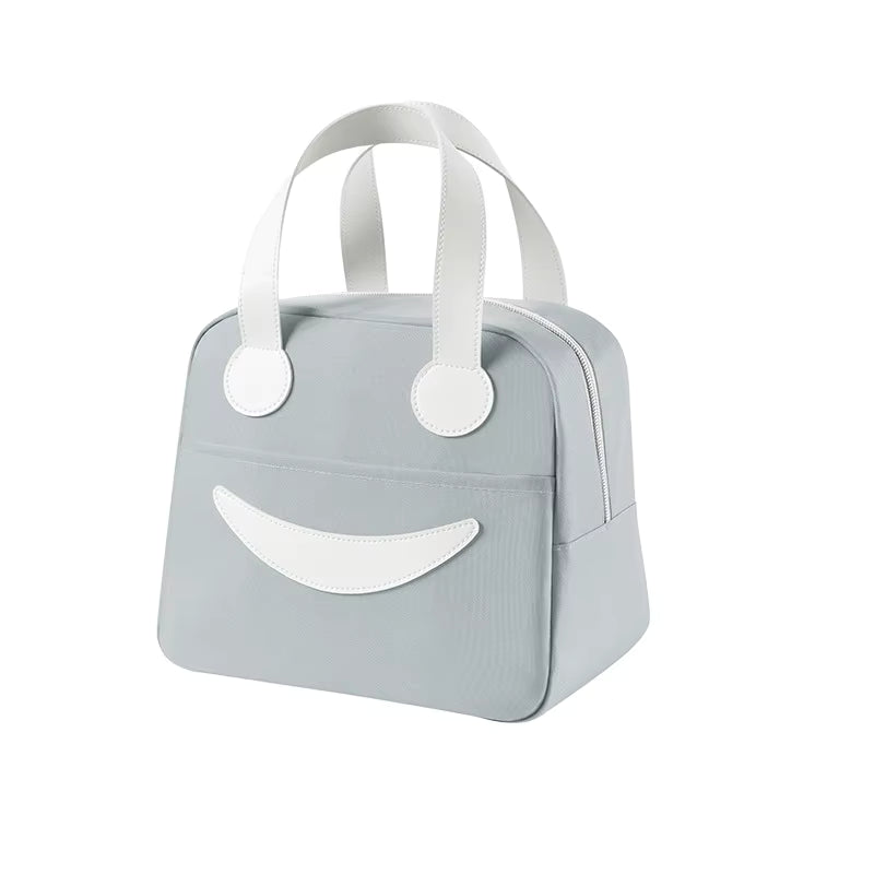 A light gray soft-sided handbag with white handles and a white smiley face design on the front, shown against a plain white background.