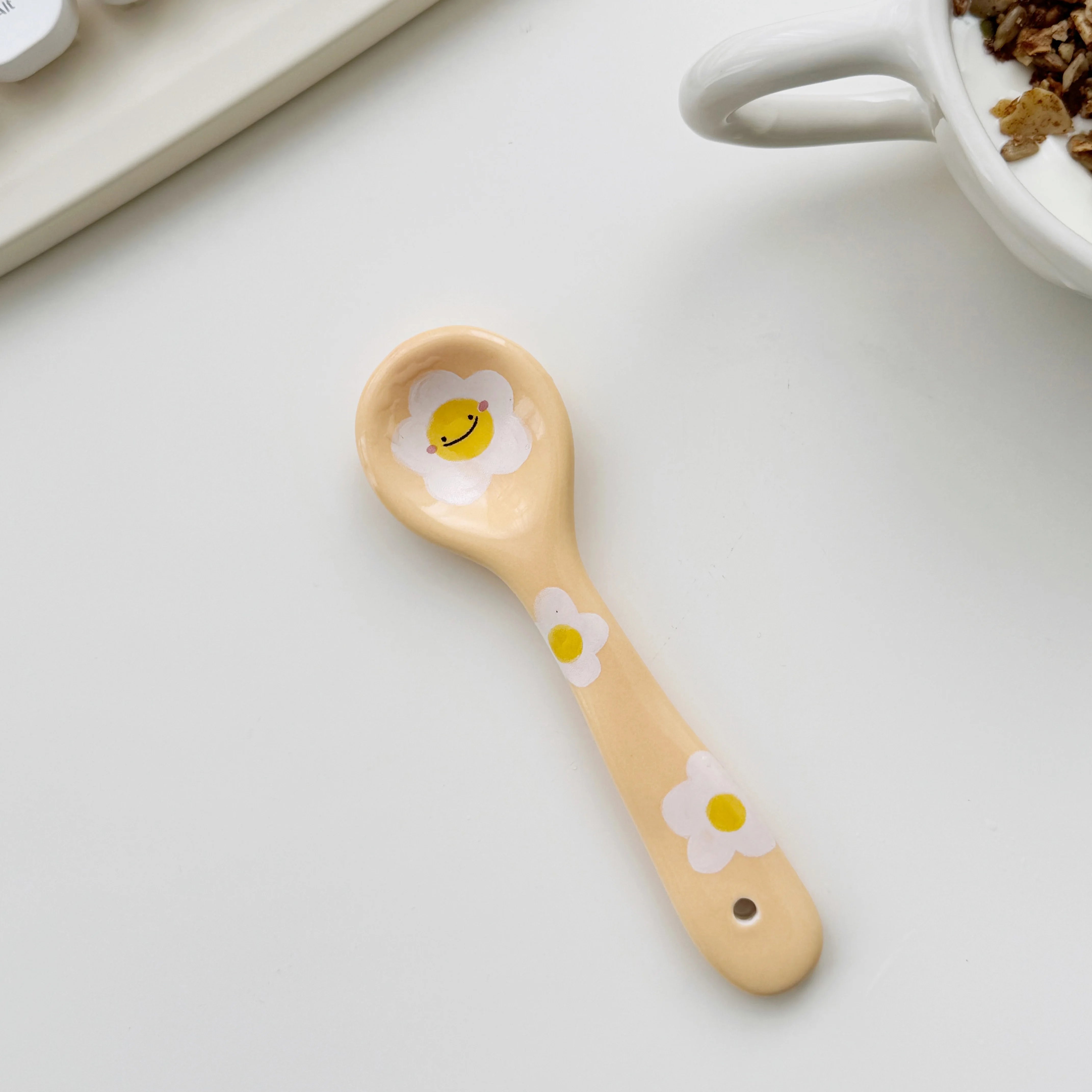 A yellow smiley face kawaii spoon on a kitchen table